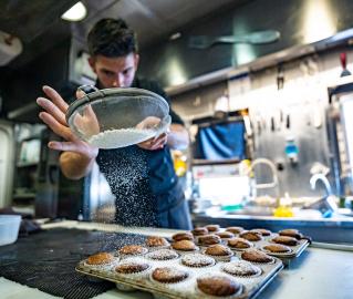 José Vela masterfully dusts powdered sugar over the afternoon’s sweet treat. 