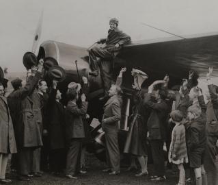 Historical photo of Amelia Earhart standing on airplane