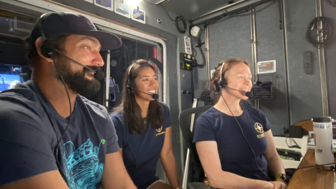Team members Daniel Kinzer, Ariana Agustinas, and Jennie Berglund sit together in the broadcast studio