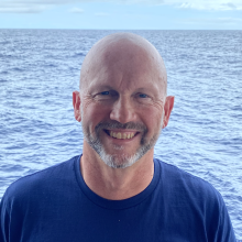 Cathal Kirwan headshot in front of the ocean 