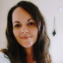 Headshot of Dorimar a woman with brown hair wearing a white shirt