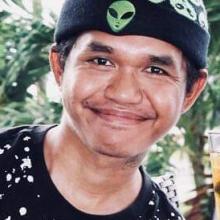 Telbakes headshot smiling and giving a peace sign