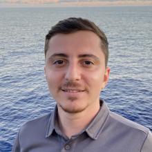 Samir headshot smiling at sea
