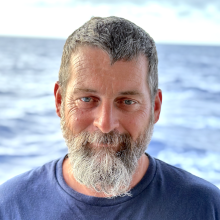 TJ Scanlon stands in front of the ocean