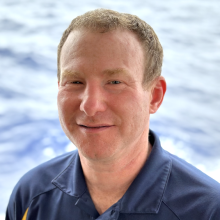 Adam Soule headshot in front of the ocean