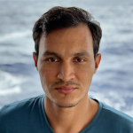 Andres stands in front of the ocean 