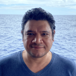 Quinardo headshot in front of the ocean