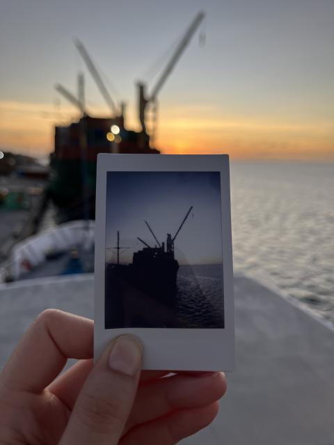 A sunset behind cargo ships in port