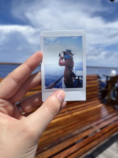 A man looks out at the horizon through binoculars