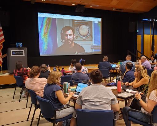 Teachers watch a screen showing Science Communication Fellow Brandon