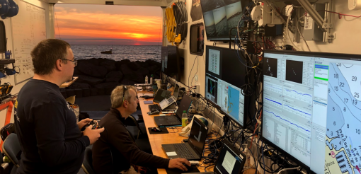 team in control van works while ASV is seen outside at sunset