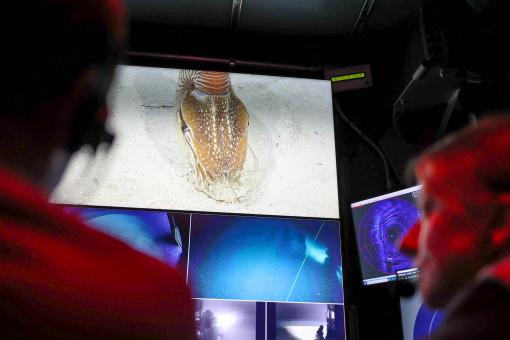 Nautilus on screen between two team members in the control room
