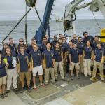 Group picture of 30 explorers on the back deck of the ship